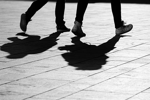 istock sun casting shadow over two people walking on the street 508189266