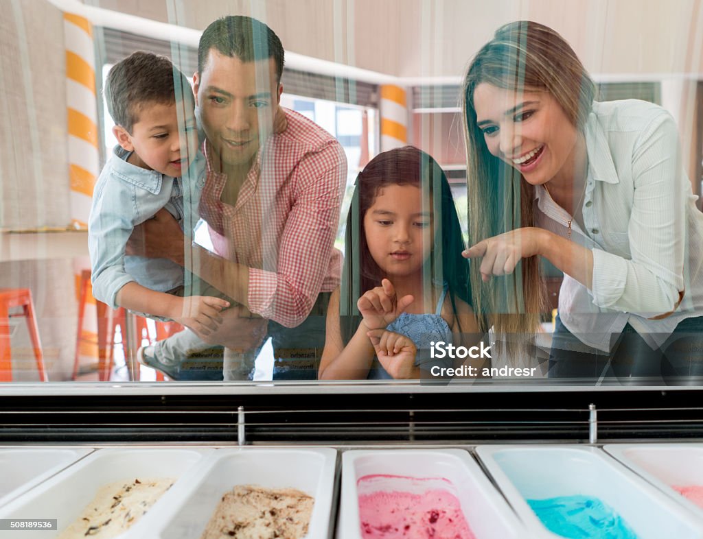 Family at an ice cream shop Happy family at an ice cream shop choosing the flavor on the window shop Ice Cream Stock Photo
