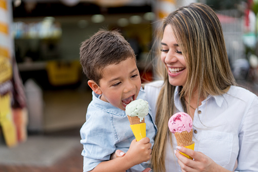 Mother and son eating an ice cream and looking very happy - family concepts