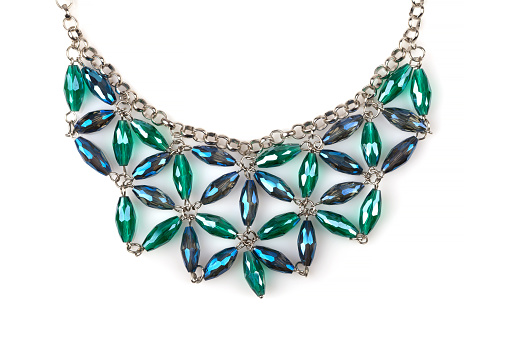 Detail of a silver necklace with blue and green rhinestones