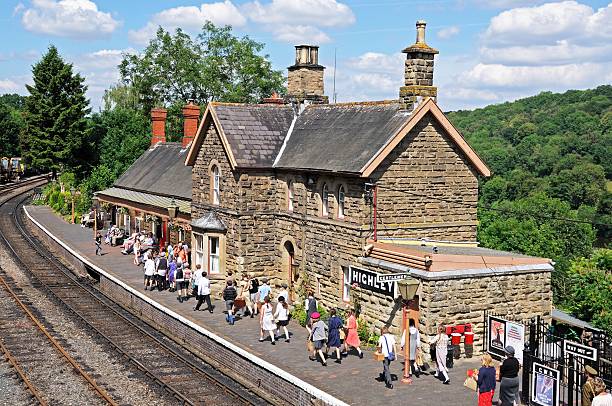 Highley, United Kingdom - July 10, 2014:  View of the railway platform and station building with a party of school children re-enacting World War II evacuees holding their brown boxes containing gas maks, Severn Valley Railway, Highley, Worcestershire, England, UK, Western Europe.