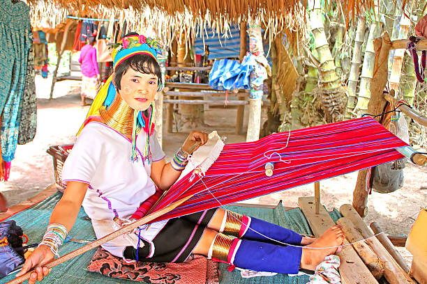 Unidentified Padaung (Karen) tribe woman weave on traditional device Mae Hong Son, Thailand - June 17, 2014: Unidentified Padaung (Karen) tribe woman weave on traditional device near Mae Hong Son, Thailand, Chiang rai, Karen Long Neck hill tribe village. Padaung women wear brass rings on the neck since the age of 5 years unidentified padaung karen tribe woman weave on traditional device stock pictures, royalty-free photos & images