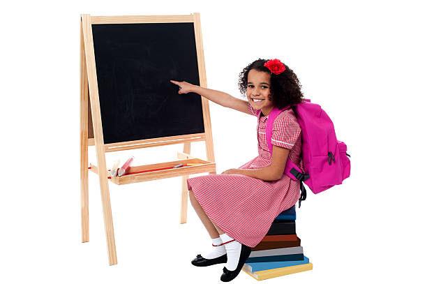 istock Cute smiling student pointing at blank chalkboard 508198969