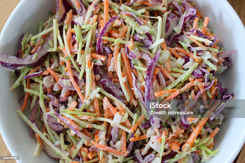 Homemade coleslaw, shredded red cabbage, grated carrot, sliced onion, mayonnaise Photo showing a white dish of homemade coleslaw, made with shredded red cabbage, grated carrot and slices of mild Spanish sliced onion, mixed with a generous amount of low-calorie mayonnaise. Coleslaw Stock Photo