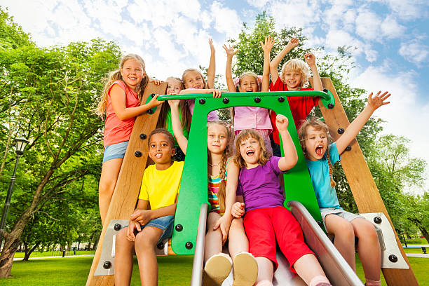 istock Excited kids on playground chute with arms up 508201285