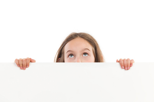 Close-up of a girl looking up over the white board. Studio shot isolated on white.