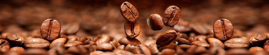 Falling coffee beans closeup in a panoramic image