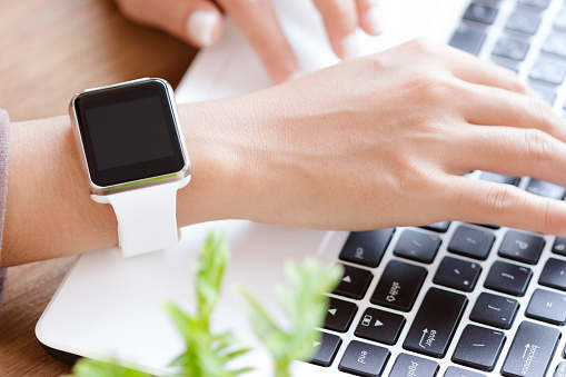 Bangkok, Thailand - jan 17, 2016 : Hand wearable apple watch typing on laptop, apple watch is new smart watch technology developed by apple Inc.