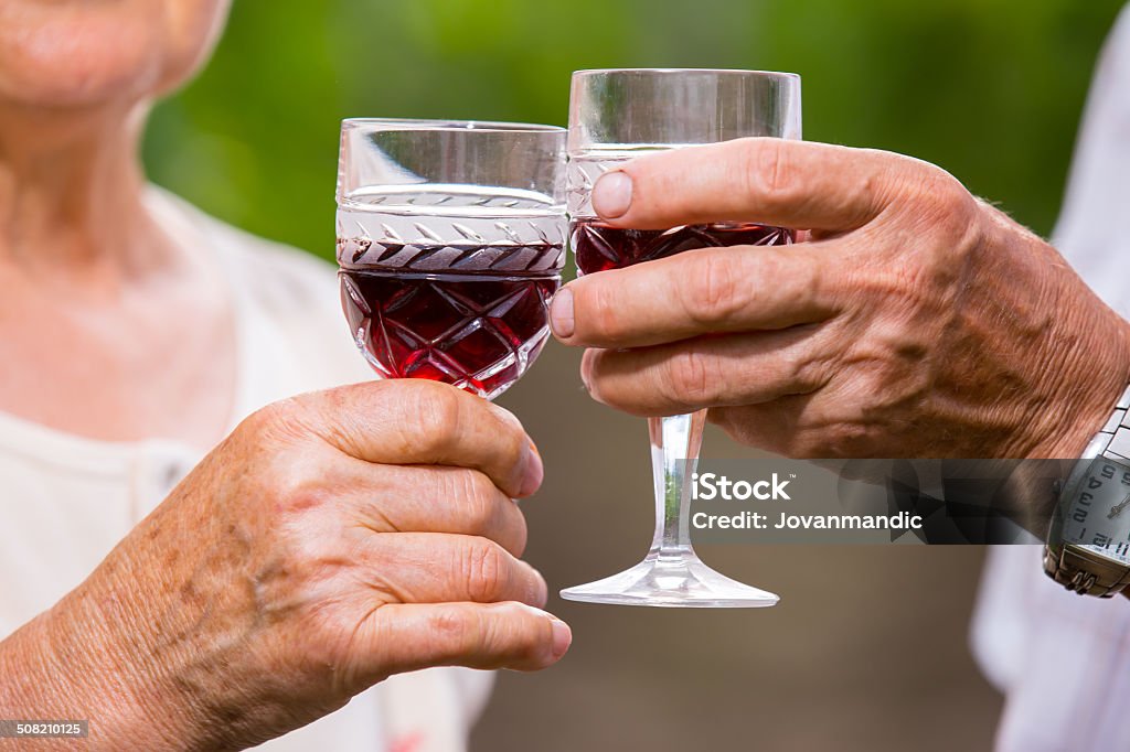 Senior couple standing in vineyard, holding glasses of wine. Senior couple  in vineyard, holding glasses of wine. 70-79 Years Stock Photo