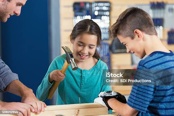 Little Girl Uses Hammer In Daycamp At Local Makerspace Stock Photo - Download Image Now