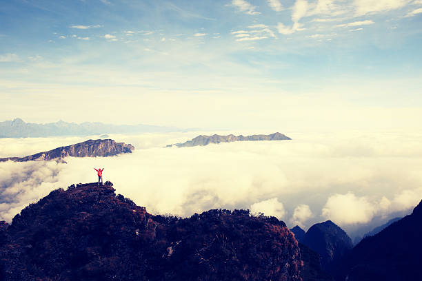 istock cheering young woman hiker open arms on mountain peak 508214492