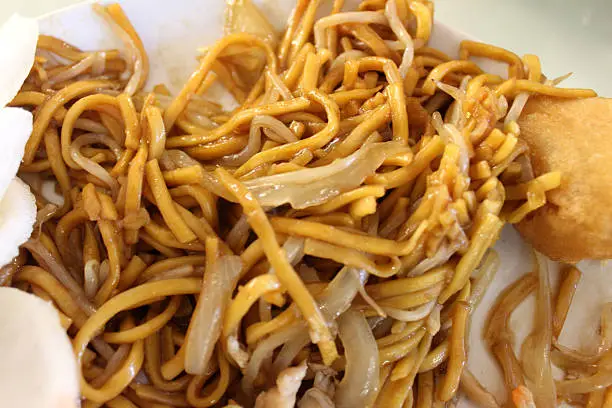 Photo showing a popular Chinese takeaway dish - chicken chow mein.  This tasty stir-fried chicken dish comprises bean sprouts, sliced spring onions, soy sauce, black pepper, five-spice, sesame oil, cornstarch (cornflour) and egg noodles.
