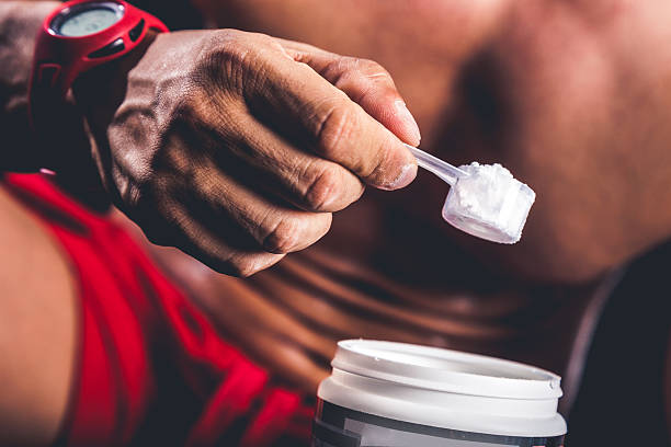 Man holding protein bottle Man holding protein bottle after workout. amino acid photos stock pictures, royalty-free photos & images