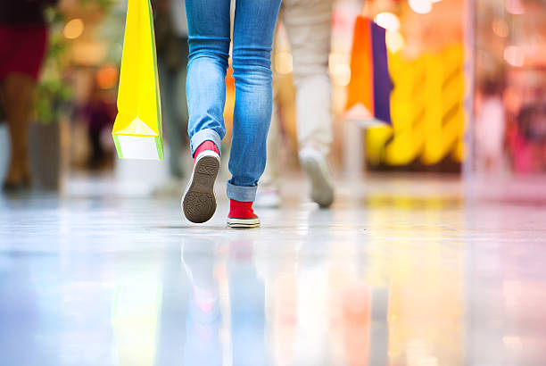 Girl with shopping bags Shopping time, closeup of teenage girl legs with shopping bags at shopping mall running shoes on floor stock pictures, royalty-free photos & images