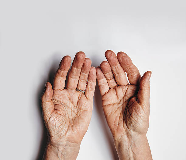 Pleading hands of old woman Top view of two empty female hands over grey background. Senior woman hands pleading. Wrinkled palms of aged woman with copy space. pleading photos stock pictures, royalty-free photos & images