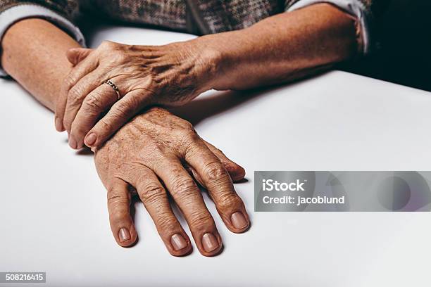 Niña Con Las Manos Sobre Una Mesa Foto de stock y más banco de imágenes de 70-79 años - 70-79 años, Actividad inmóvil general, Adulto