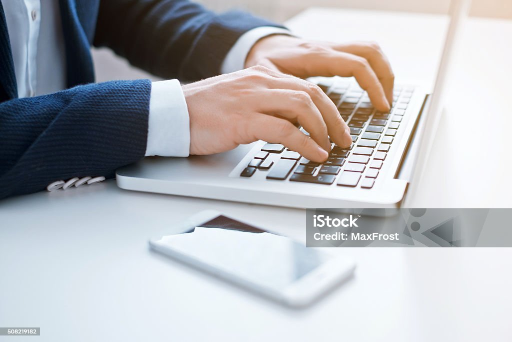 Businessman using laptop at the office. Close-up image. Adult Stock Photo