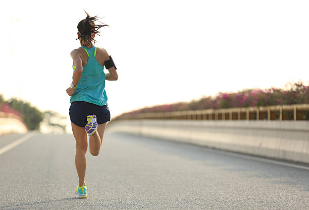 junge frau läufer laufen auf city bridge road - joggen stock-fotos und bilder