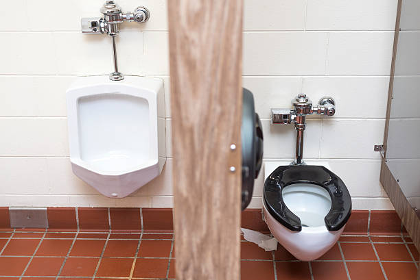 istock public bathroom with urinal and toilet on either side 508224034