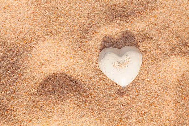 istock Lovely white shell heart on sand 508230919