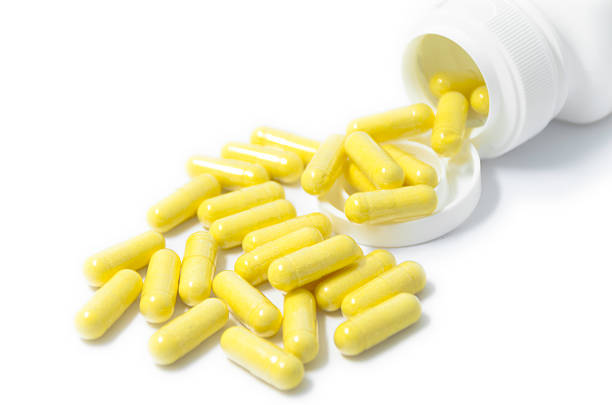 istock yellow capsule pills supplement spilled isolated 508231785
