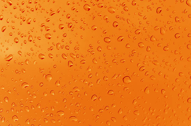 Orange plastic with water drops macro photo as background