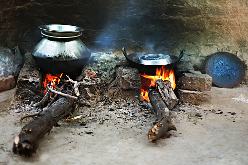Cooking Food (wood burning stove). Stove made from mud that is constructed using brick and local materials.
