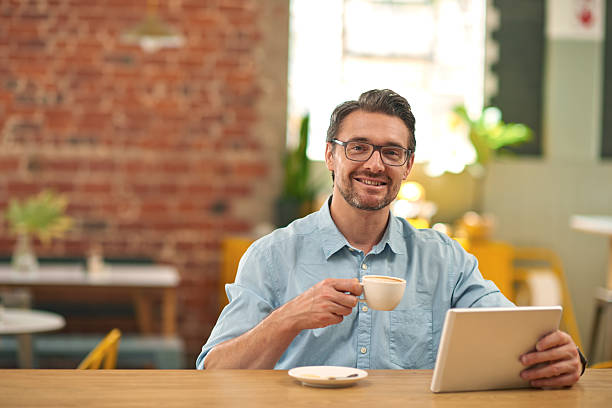 istock Handsome male with digital tablet sitting at coffee shop 508248484