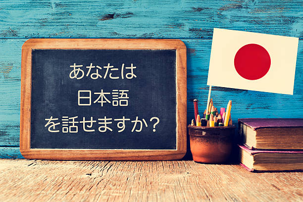 question do you speak Japanese? written in Japanese a chalkboard with the question do you speak Japanese? written in Japanese, a pot with pencils, some books and the flag of Japan, on a wooden desk learning Japanese Language stock pictures, royalty-free photos & images