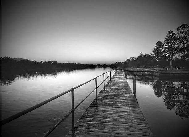 istock Sunrise waterscape with wharf and tree reflections in monochrome 508249374