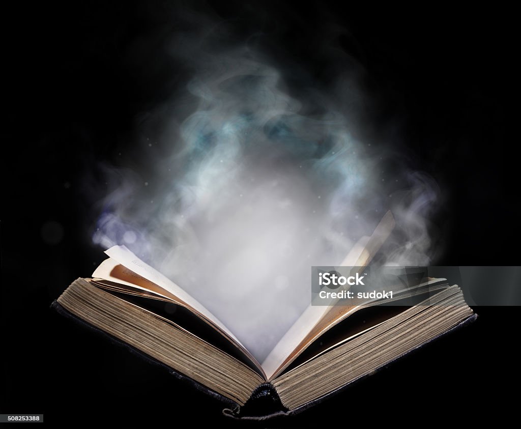 Ancient open book in the magical smoke Dust Stock Photo