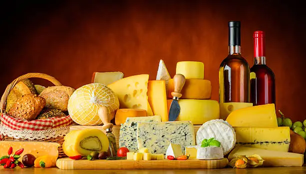 different types of cheese with food, bread and wine