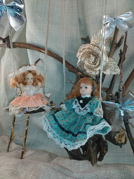 Photo of Porcelain dolls on swings photo.