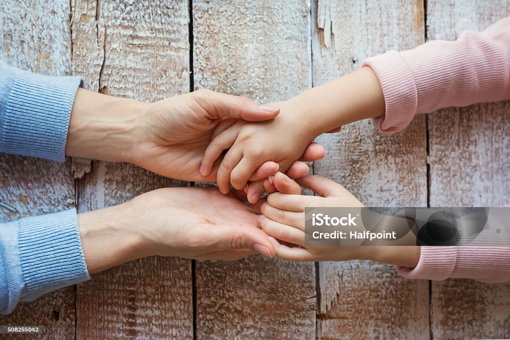 Mother and daughter Unrecognizable mother and her daughter holding hands. Mother Stock Photo