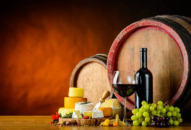 Red-wine with cheese and barrel in still lif