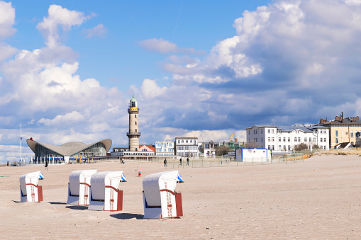 Image of sandy beach of Warnemunde with beach chairs and Lighthouse, Germany
