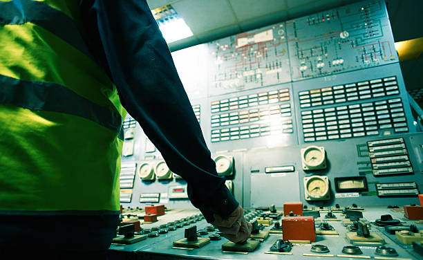 operator hand on the control panel power plant stock photo