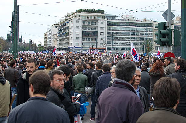 Athens-Greece/ 7-September 2025: Over an  Avenue are march in line, Greece Guards (Evzonen) wearing the traditional costumes. Surround by a crowd of tourists.
