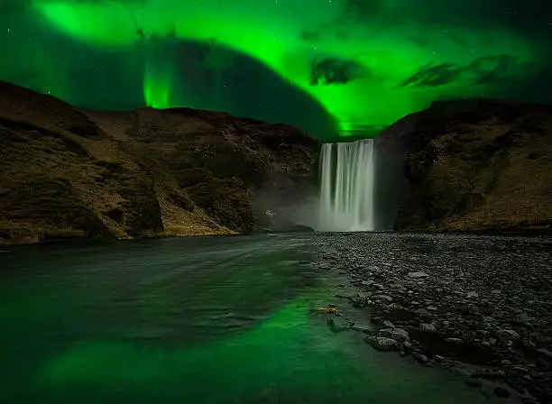 Flash of Aurora polaris above skogafoss waterfall, iceland