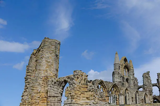 Ruined walls of Whitby Abbey set against a blue summer sky