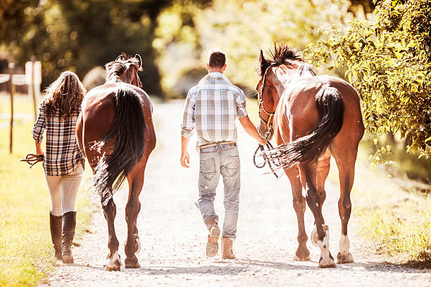 Couple walking their horses.