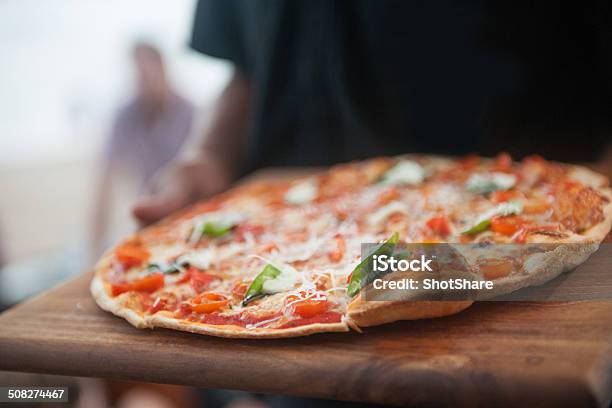 Waiter Serving Pizza Stock Photo - Download Image Now - Pizza, Thin, Pastry Dough