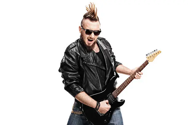 Young punk rocker playing electric guitar isolated on white background