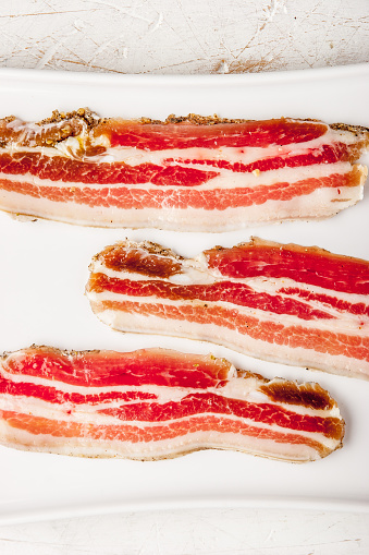 Single Pork Belly Bacon rasher isolated on white background.