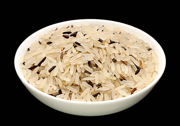 riz sauvage isolé sur fond noir - rice black wild rice dry photos et images de collection