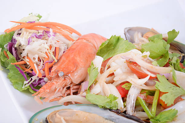 Seafood salad fruit de mer shrimp, mussels, squid, rapawn, prawn, green mixed leaf dish fresh food background on the table rustic food top view copy space keto paleo diet vegetarian pescetarian