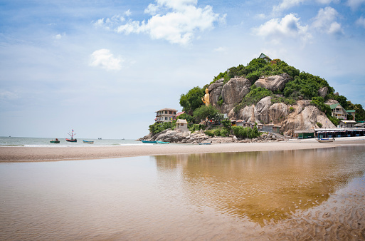 The Beach At Hua Hin In Thailand With A Large Golden Standing Buddha Statue In The Background