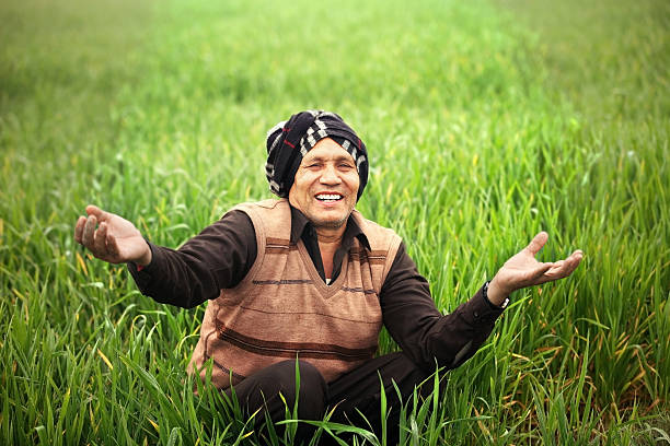 Close-Up Portrait Of Smiling Farmer Wearing Turban On Field