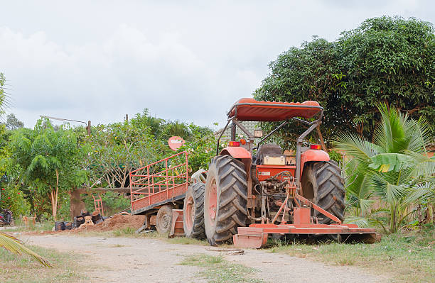 istock Red tractor with a harrow on ground. 508291088