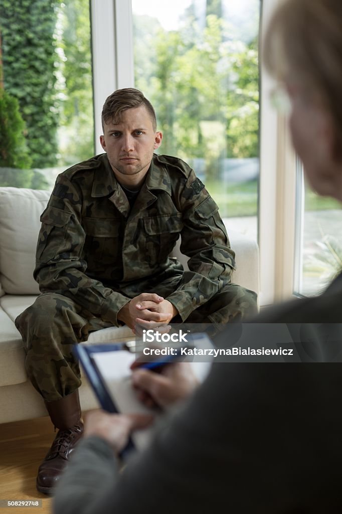 Therapist diagnosing soldier Photo of female therapist diagnosing soldier suffering from trauma Healthcare And Medicine Stock Photo